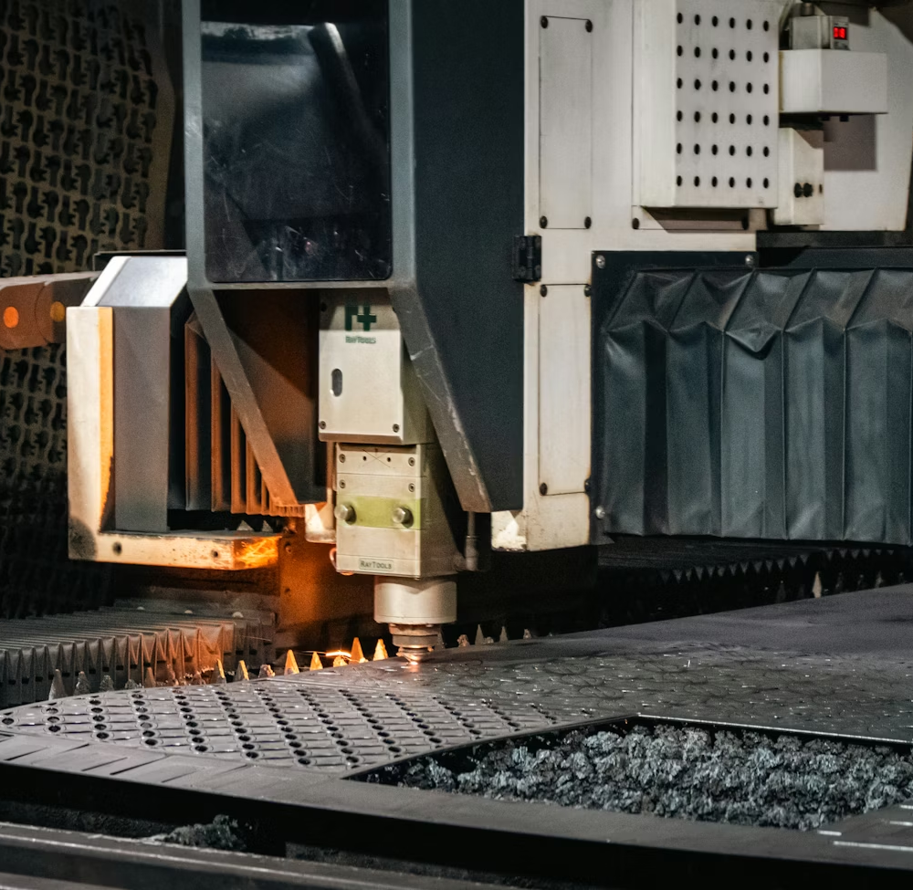 Maszyna laserowa tnąca arkusz metalu w zakładzie produkcyjnym.
